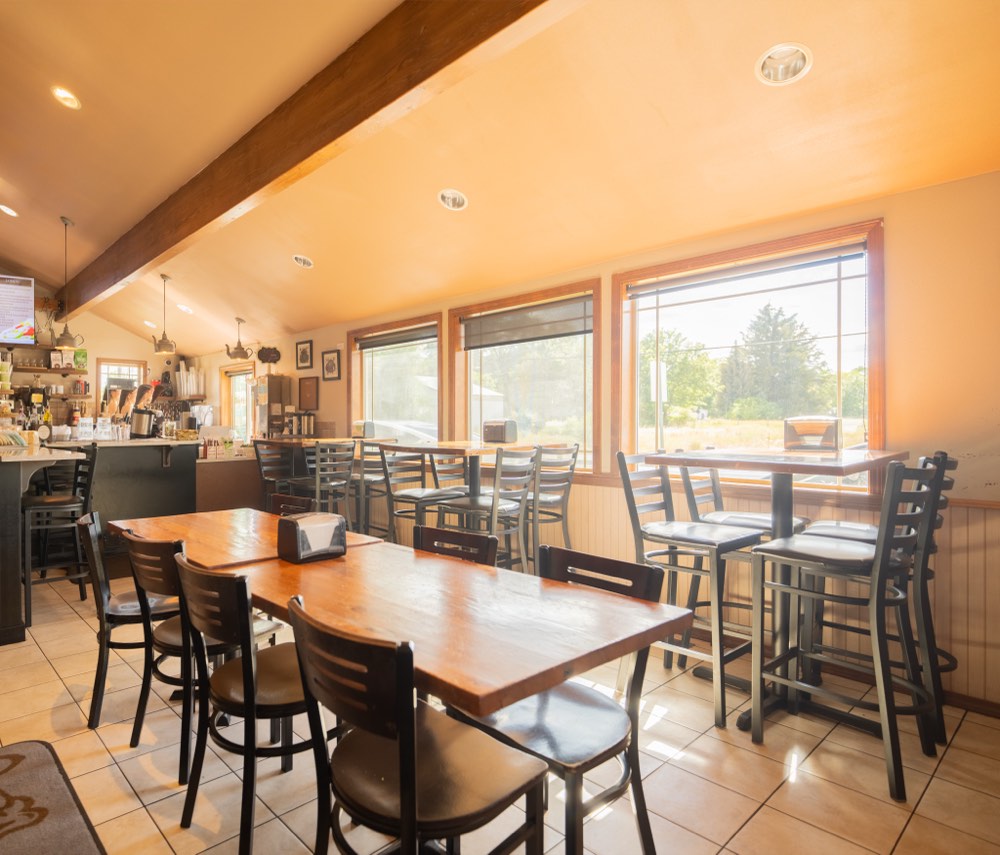 Morning sun across the dining room tables, looking toward the coffee counter